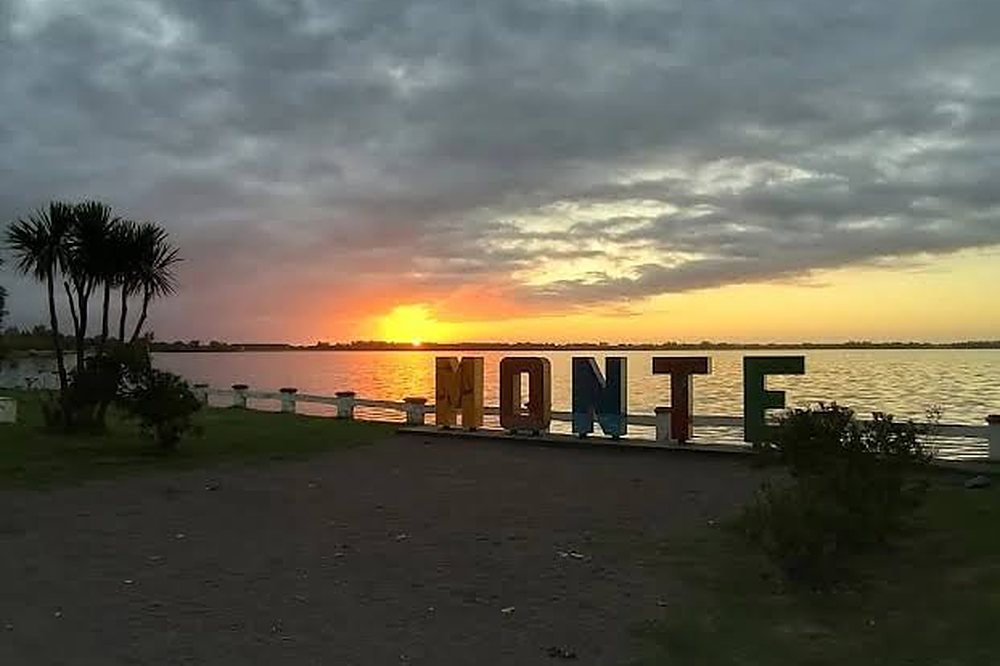 Cartel de Monte frente a la laguna al atardecer